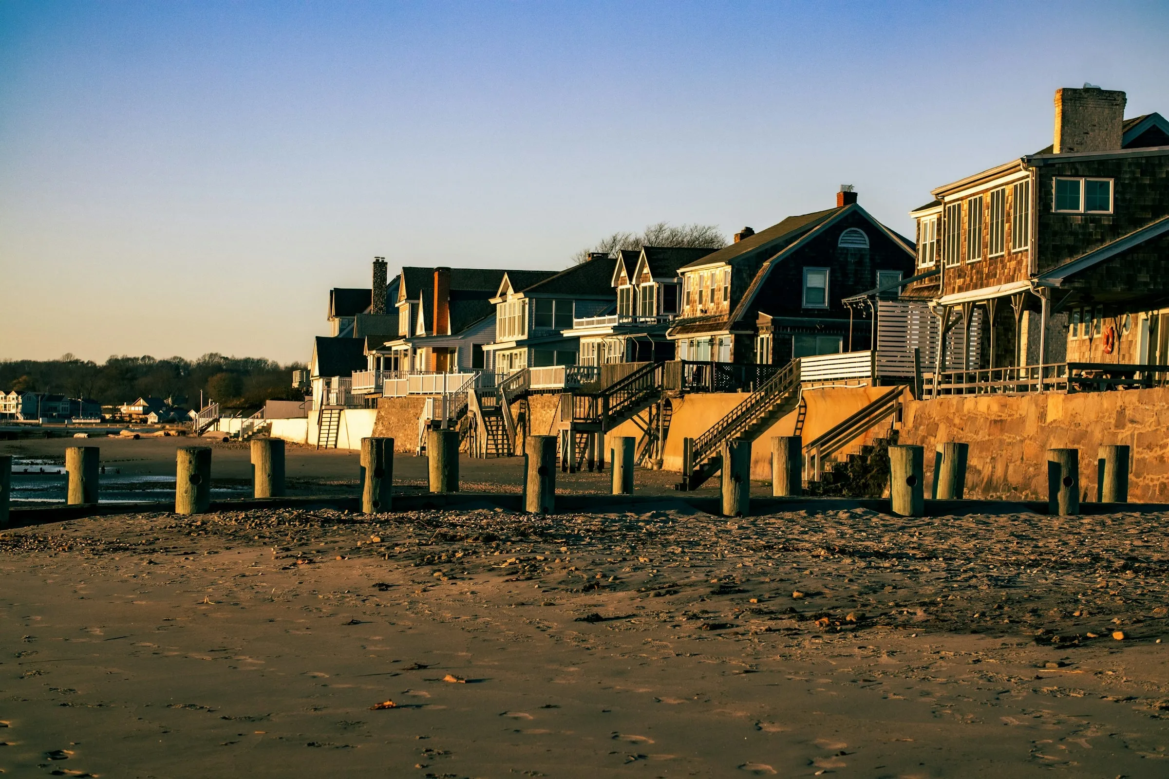 Shingled beach houses along the Old Saybrook shoreline in late-afternoon sun